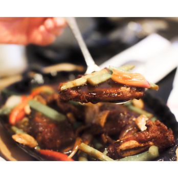 Ginger Bistro - a hand holding a spoon full of food - Barbeque Near Me - Fort Myers, Florida