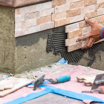Cornerstone Flooring - a man laying tile on the floor - Flooring Near Me