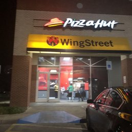 a car parked in front of a pizza hut