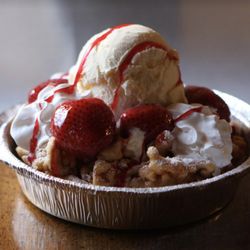 Fairgroundz - Strawberry Delight funnel cake topped with ice cream, whipped cream, and strawberry syrup drizzle.