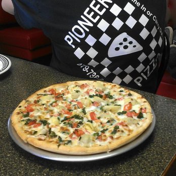 Pioneer Pizza - a man sitting at a table with a pizza - Pizza Near Me - Gentry, Arkansas