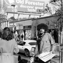 Telegraph Berkeley Historical Walking Tour - Hippie on Telegraph.  He had just stolen a bunch of newspapers from a vending machine.  He is happy because LBJ just died. - - -Tom Brody