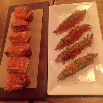 Niu Kitchen - Toast with tomatoes and garlic oil. Anchovies with a potato chip topping sits atop more grated tomatoes - Catalan Near Me - Miami, Florida Niu Kitchen - Toast with tomatoes and garlic oil. Anchovies with a potato chip topping sits atop more grated tomatoes - Catalan Near Me - Miami, Florida