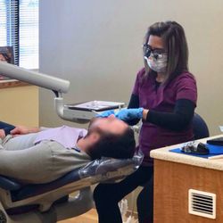 Dan B Hilo, DDS - One of the hygienists performing a routine cleaning on a patient in order to maintain optimal tooth health