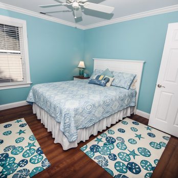 Supernova Construction & Remodeling - a bedroom with blue walls and white furniture - General Contractors Near Me