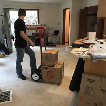 Mighty Michigan Movers - Adam is working hard moving boxes out of the home. - Movers Near Me Mighty Michigan Movers - Adam is working hard moving boxes out of the home. - Movers Near Me
