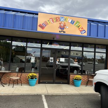 Bittersweet Java - Front - Bittersweet Java is a coffee shop with a bright sign, large glass windows, and outdoor seating with chairs and potted flowers. - Coffee & Tea Near Me - Ruckersville, Virginia