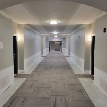 Genessis Group LLC - a long hallway leading to an elevator - General Contractors Near Me