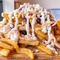 Santorini's - Loaded Feta Fries topped with cabbage, feta, and a delicious blend of our house-made Tzatziki and Roasted Pepper Sauces (both Gluten Free)