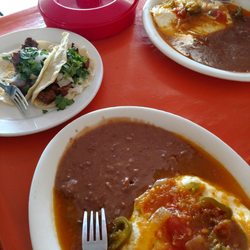 Huevos Rancheros with beans and tortillas. 2 goat tacos and 1 steak taco.
