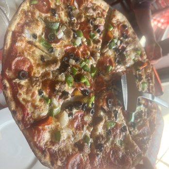 Sisters Restaurant - a pizza with a slice taken out of it - Italian Near Me - Boca Grande, Florida