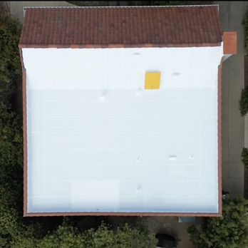 SLR Roofing - The yellow object is a new hatch SLR installed on the pitched part of the roof. - Roofing Near Me - Reseda, California