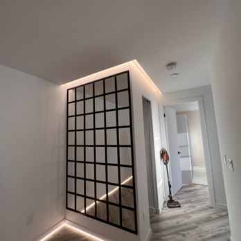 Top Iconic Contractors - a room with a mirror and a light fixture - General Contractors Near Me - Brooklyn, New York Top Iconic Contractors - a room with a mirror and a light fixture - General Contractors Near Me - Brooklyn, New York