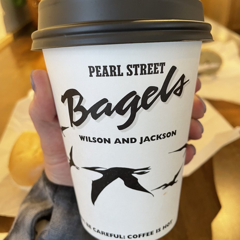 Pearl Street Bagels - a person holding a coffee cup - Bagels Near Me - Jackson, Wyoming Pearl Street Bagels - a person holding a coffee cup - Bagels Near Me - Jackson, Wyoming