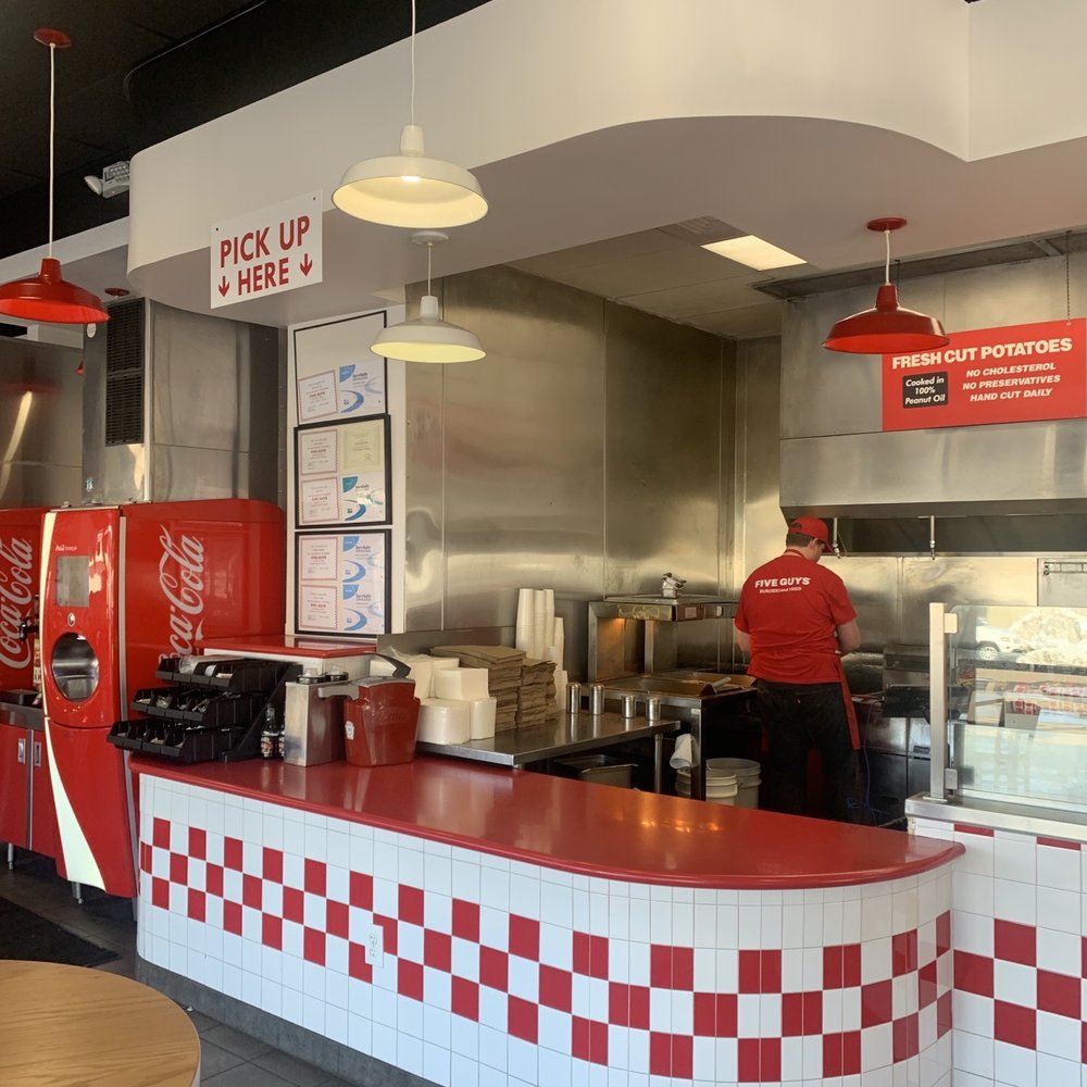 Five Guys - a man in a red shirt working at a fast food restaurant - Fast Food Near Me - Flagstaff, Arizona