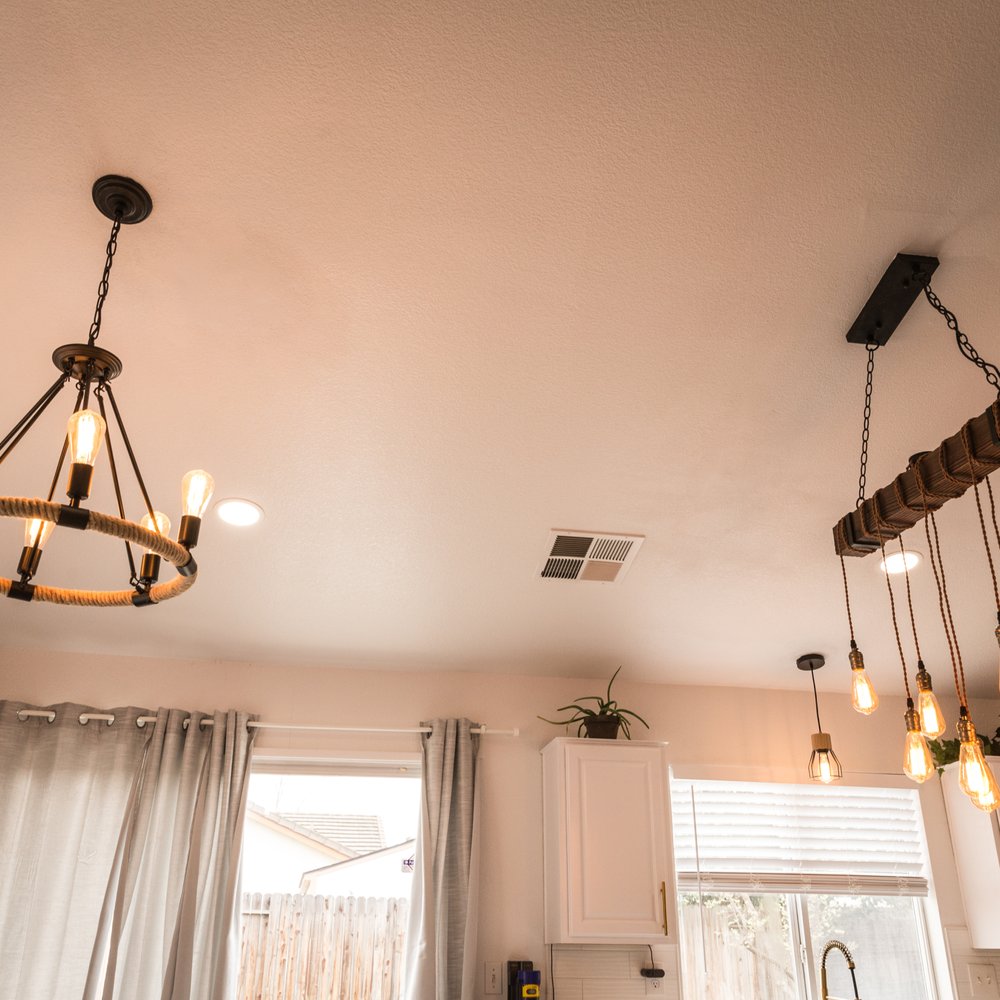 Danny's Floors - a kitchen with white cabinets and a chandelier - Flooring Near Me - Elk Grove, California