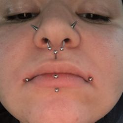 East Coast Ink - In this photo you can see the droopy side(left) along with the spot where I was first pierced on that side.(Red dot)