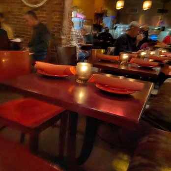 Tapas Teatro - restaurant - Interior of a restaurant with tables set with plates, napkins, and candles, and patrons seated and dining in a cozy, dimly lit environment. - Tapas Bars Near Me - Baltimore, Maryland