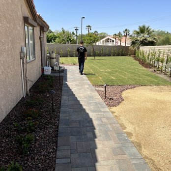 Honor Landscape - a person walking down a sidewalk - Landscaping Near Me Honor Landscape - a person walking down a sidewalk - Landscaping Near Me