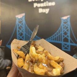 Potato Pit & Juice Bar - Poutine with mural in background