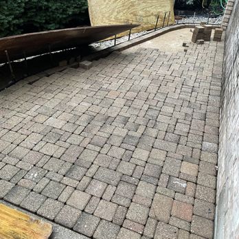 Pappas Contracting - a brick patio with a wooden bench - General Contractors Near Me