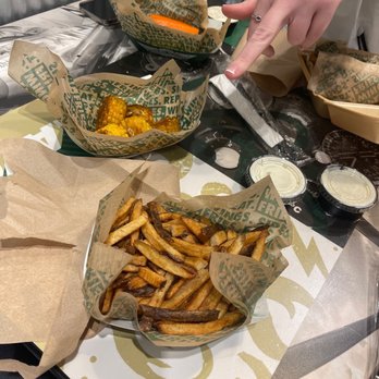 Wingstop - a person preparing food on a table - Chicken Wings Near Me - Utica, New York