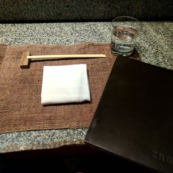 Zuma - Table setting, woven mat, wooden chopsticks resting, and a fancy leather bound menu. - Sushi Bars Near Me - New York, New York Zuma - Table setting, woven mat, wooden chopsticks resting, and a fancy leather bound menu. - Sushi Bars Near Me - New York, New York