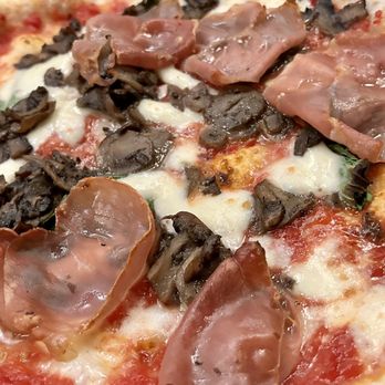 Via Tevere Pizzeria - a close up of a pizza - Italian Near Me - Vancouver, British Columbia
