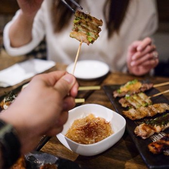 Zakkushi on Queen West - a woman eating with chopsticks - Japanese Near Me - Toronto, Ontario Zakkushi on Queen West - a woman eating with chopsticks - Japanese Near Me - Toronto, Ontario
