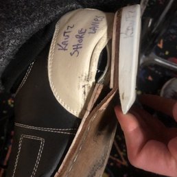 a person's hand holding a shoe a person's hand holding a shoe
