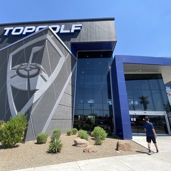 Topgolf - a man walking in front of a building - Sports Bars Near Me - Glendale, Arizona Topgolf - a man walking in front of a building - Sports Bars Near Me - Glendale, Arizona
