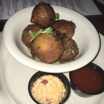 Mainland Container Co Kitchen & Bar - Hush puppies served with pimento cheese and drizzled with honey. Yum yum. - Bars Near Me - Mount Pleasant, South Carolina Mainland Container Co Kitchen & Bar - Hush puppies served with pimento cheese and drizzled with honey. Yum yum. - Bars Near Me - Mount Pleasant, South Carolina