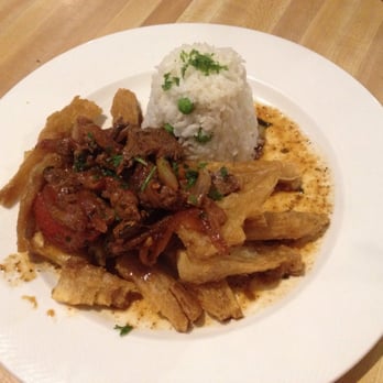 The Nibbler - Lomo Saltado: sauteed flank steak with onions, tomatoes, and cilantro over yuca fries with rice - Peruvian Near Me - Gaithersburg, Maryland