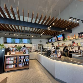 Fepo Cafe - Clean, modern, great service - Fepo Cafe's interior features a modern, clean design with a curved counter, digital menu screens, and staff preparing orders. - Coffee & Tea Near Me - New Haven, Connecticut