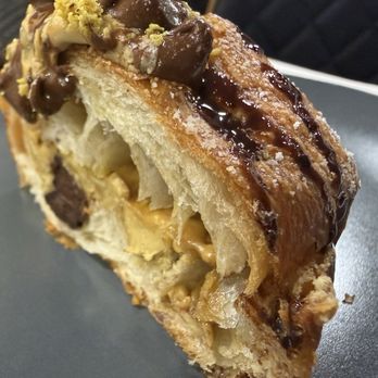 La Boulangerie Boul'Mich - Cut open, this croissant shows rich chocolate, flaky buttery layers, a hint of pistachio, and a smooth milk chocolate drizzle. - Breakfast & Brunch Near Me - Miami, Florida La Boulangerie Boul'Mich - Cut open, this croissant shows rich chocolate, flaky buttery layers, a hint of pistachio, and a smooth milk chocolate drizzle. - Breakfast & Brunch Near Me - Miami, Florida