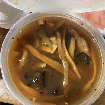 New Apolo - Hot and sour soup. Remember it has pork in it. - A plastic container filled with hot and sour soup containing vegetables, tofu, and mushrooms, served at New Apolo in Brooklyn, NY. - Chinese Near Me - Brooklyn, New York