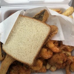 a sandwich and fries in a styrofoam container