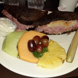 Reuben Sandwich with fruit as a side dish.