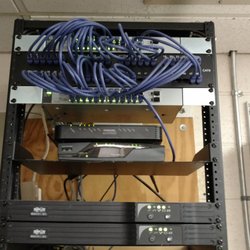 New Start Computer Repair - Network equipment rack with network switches, battery backup units and internet modem.