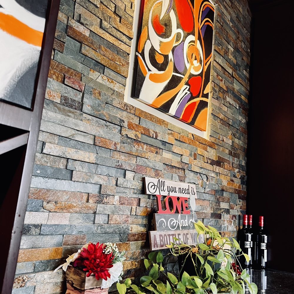 Prosecco Cafe - a table with a vase of flowers and a painting on the wall - Breakfast & Brunch Near Me - Palm Beach Gardens, Florida Prosecco Cafe - a table with a vase of flowers and a painting on the wall - Breakfast & Brunch Near Me - Palm Beach Gardens, Florida