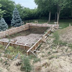 Premier Pools and Spas - Side walls are caving over the rebar and weeds have taken over most of the project.