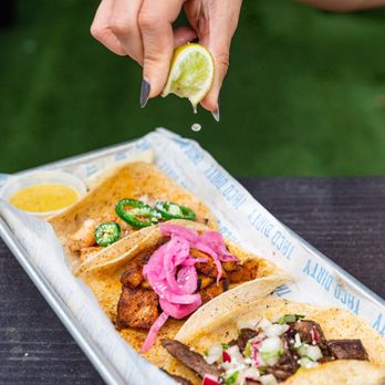 Taco Dirty - a hand sprinkling a lime over a plate of tacos - Tacos Near Me - Tampa, Florida Taco Dirty - a hand sprinkling a lime over a plate of tacos - Tacos Near Me - Tampa, Florida