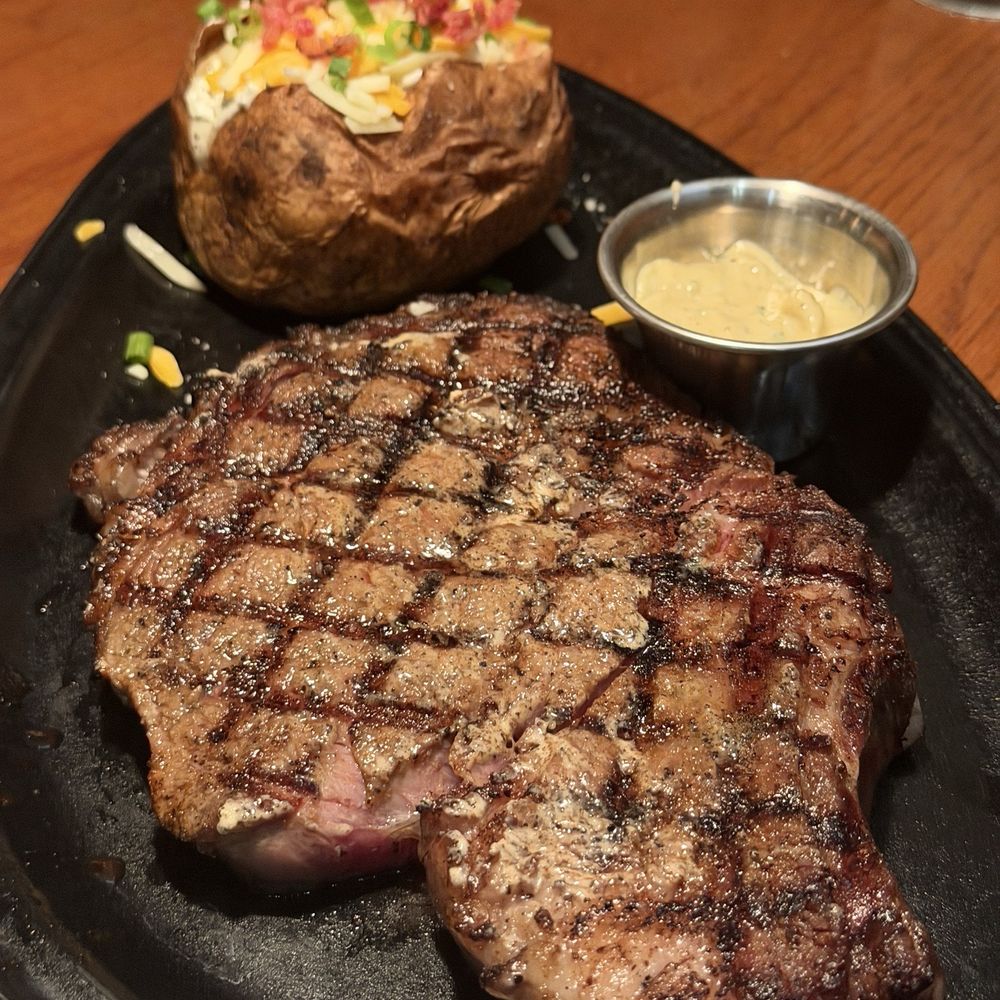 Bone-In Ribeye* 20 oz. with Roasted Garlic Butter and a Dressed Baked Potato on the side.