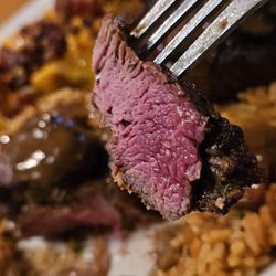 Texas Roadhouse - A fork holding a piece of the Filet cooked medium rare.