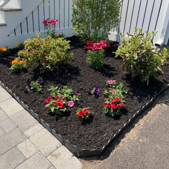Cubias Landscaping & Masonry - a flower bed in front of a white fence - Landscaping Near Me Cubias Landscaping & Masonry - a flower bed in front of a white fence - Landscaping Near Me