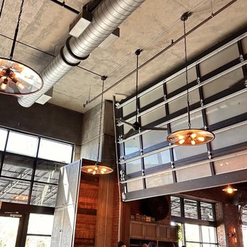 Madison Social - a group of people eating in a restaurant - New American Near Me - Tallahassee, Florida