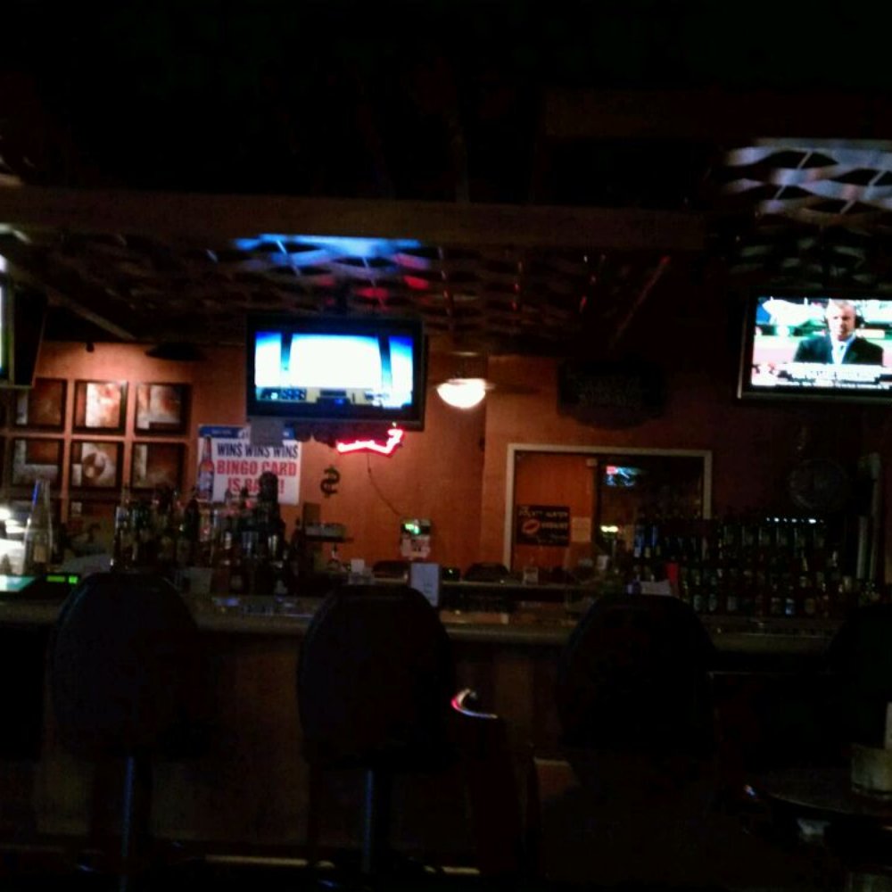 a bar with people watching tvs