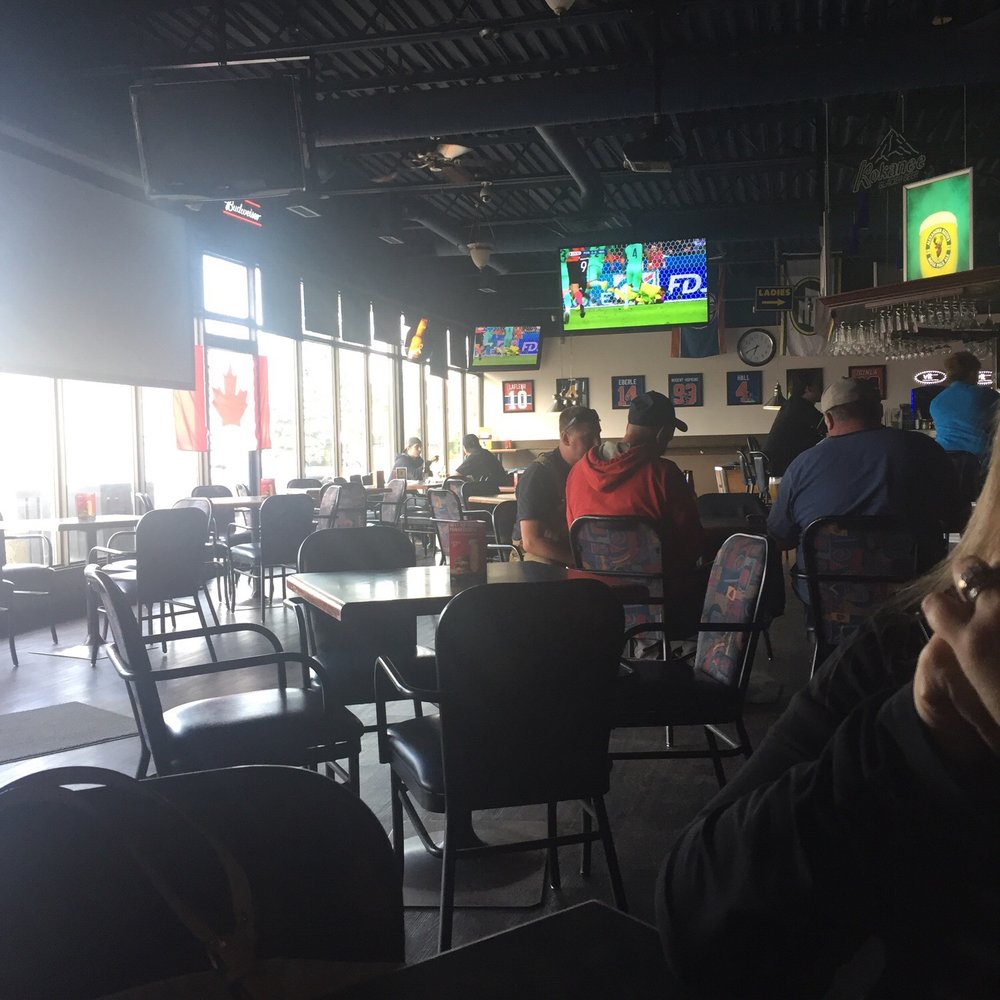 people sitting at tables and watching televisions people sitting at tables and watching televisions