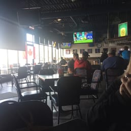 people sitting at tables and watching televisions people sitting at tables and watching televisions