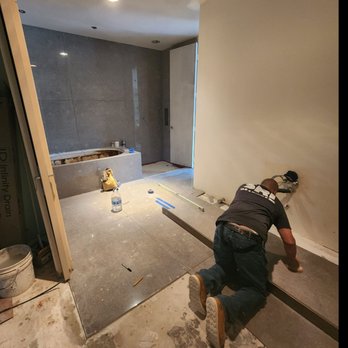 SRI Tile & Marble - a man laying on the floor - Tiling Near Me SRI Tile & Marble - a man laying on the floor - Tiling Near Me